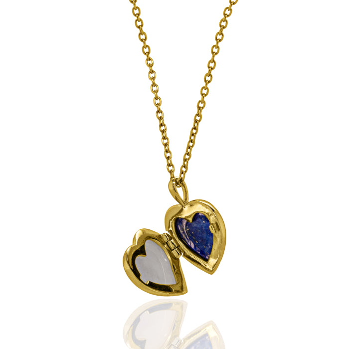 A gold heart-shaped locket necklace on a delicate gold chain, featuring one half in polished gold and the other in a deep blue stone, with the opposite half set in white stone, shown against a white background with a soft reflection.