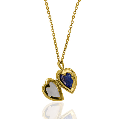 A gold heart-shaped locket necklace on a delicate gold chain, featuring one half in polished gold and the other in a deep blue stone, with the opposite half set in white stone, shown against a white background with a soft reflection.