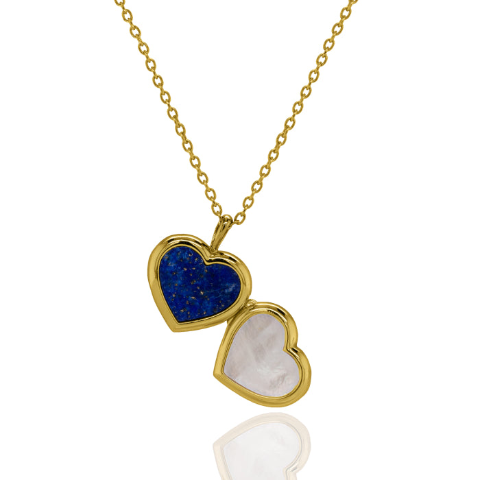 A gold heart-shaped pendant necklace with one half featuring a textured dark blue stone and the other half featuring a smooth white stone, displayed on a clean white background with a soft reflection below.