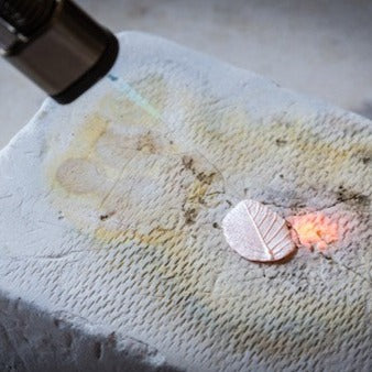 Using a torch to finish the silver clay leaf pendant